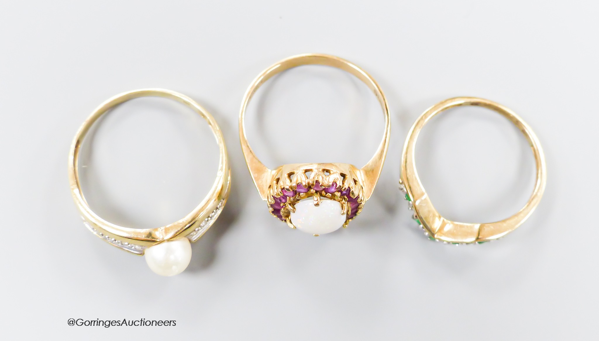 Two 9ct gold and gem set rings, ruby and white opal cluster and emerald and diamond herringbone and a 375 and cultured pearl ring, gross weight 6.8 grams.